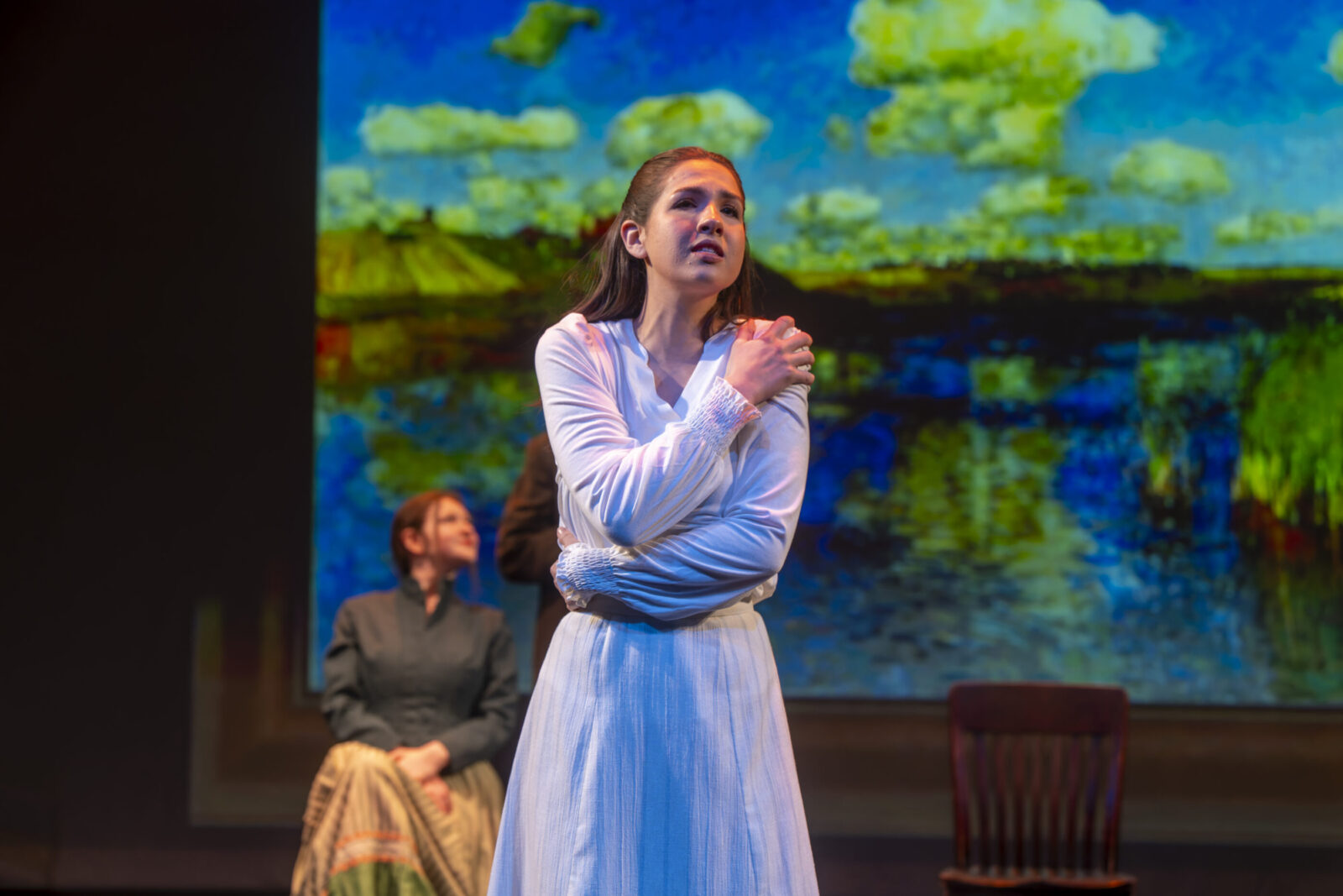 three people singing onstage together