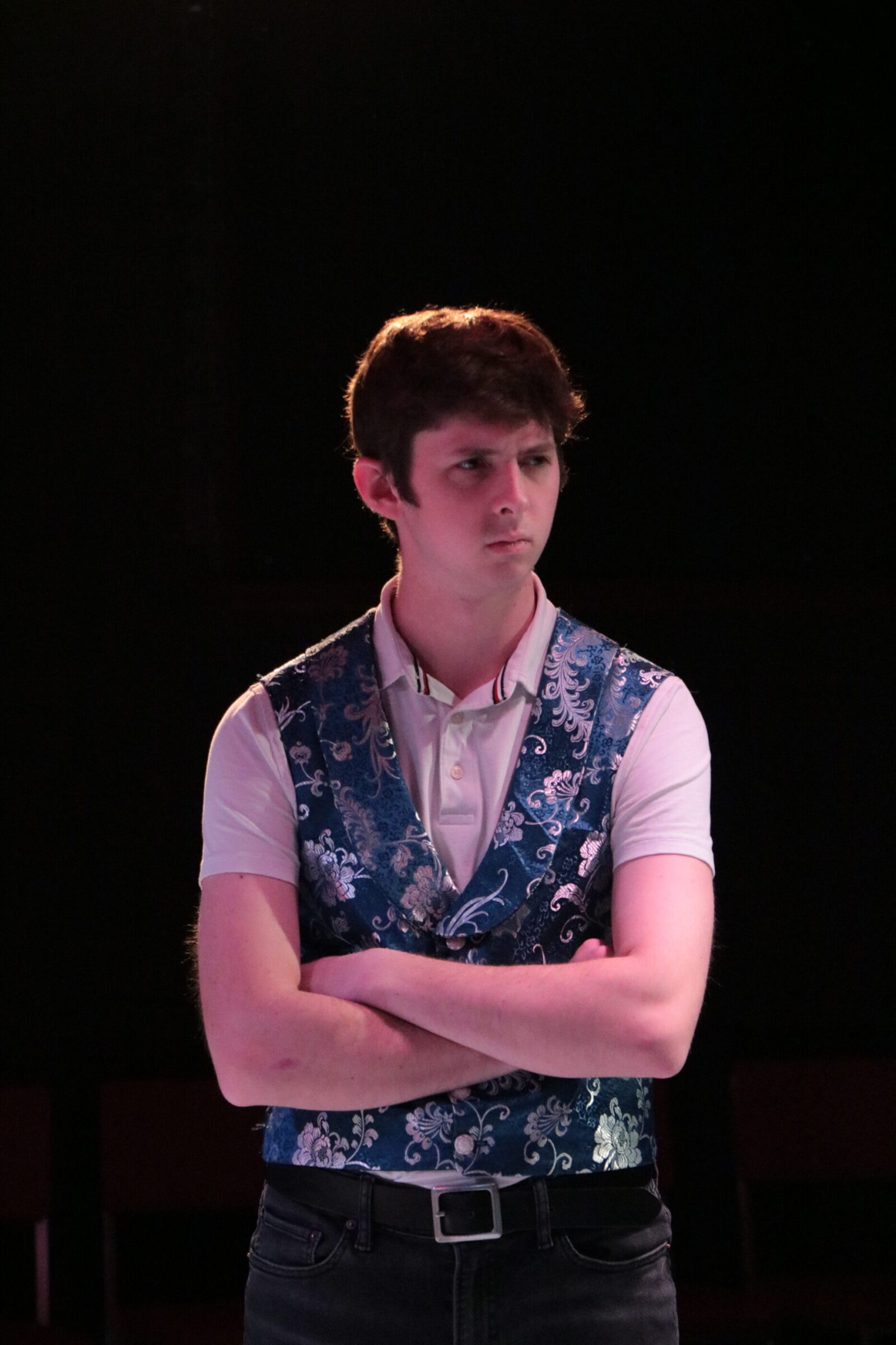 person stands with arms crossed