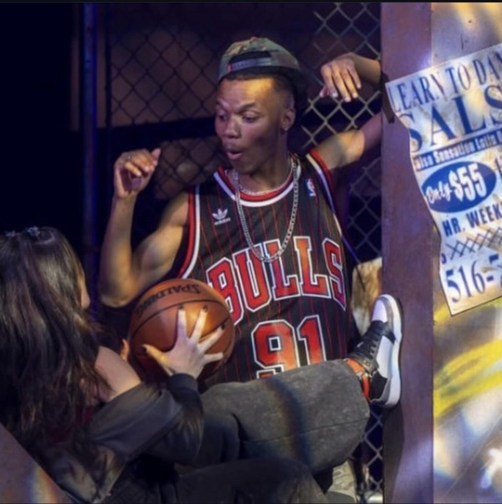 a person in a bull's jersey talking to someone with a basketball