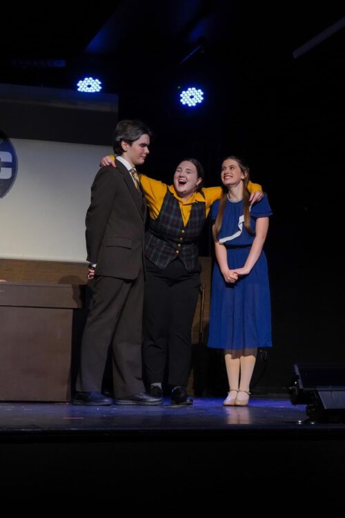 a perosn stands onstage speaking