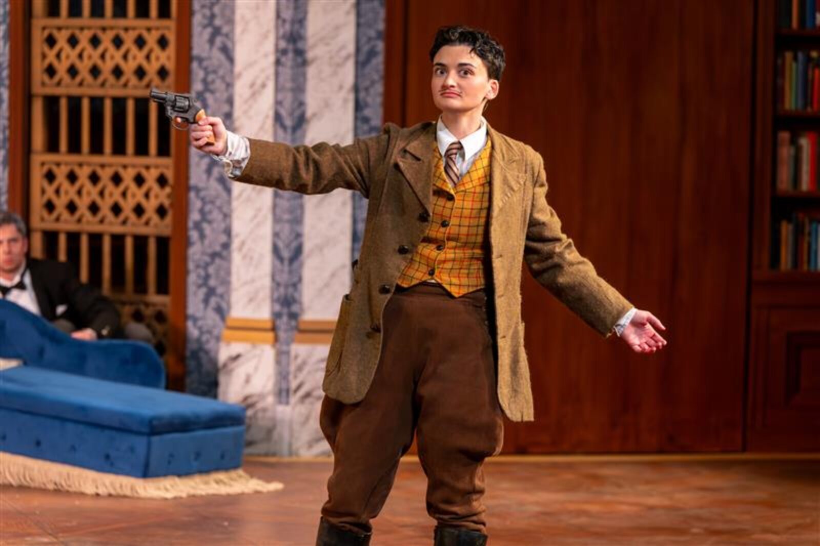 person onstage holding a fake gun