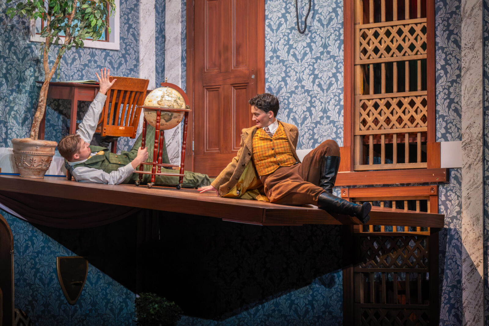 two people onstage sliding down a platform