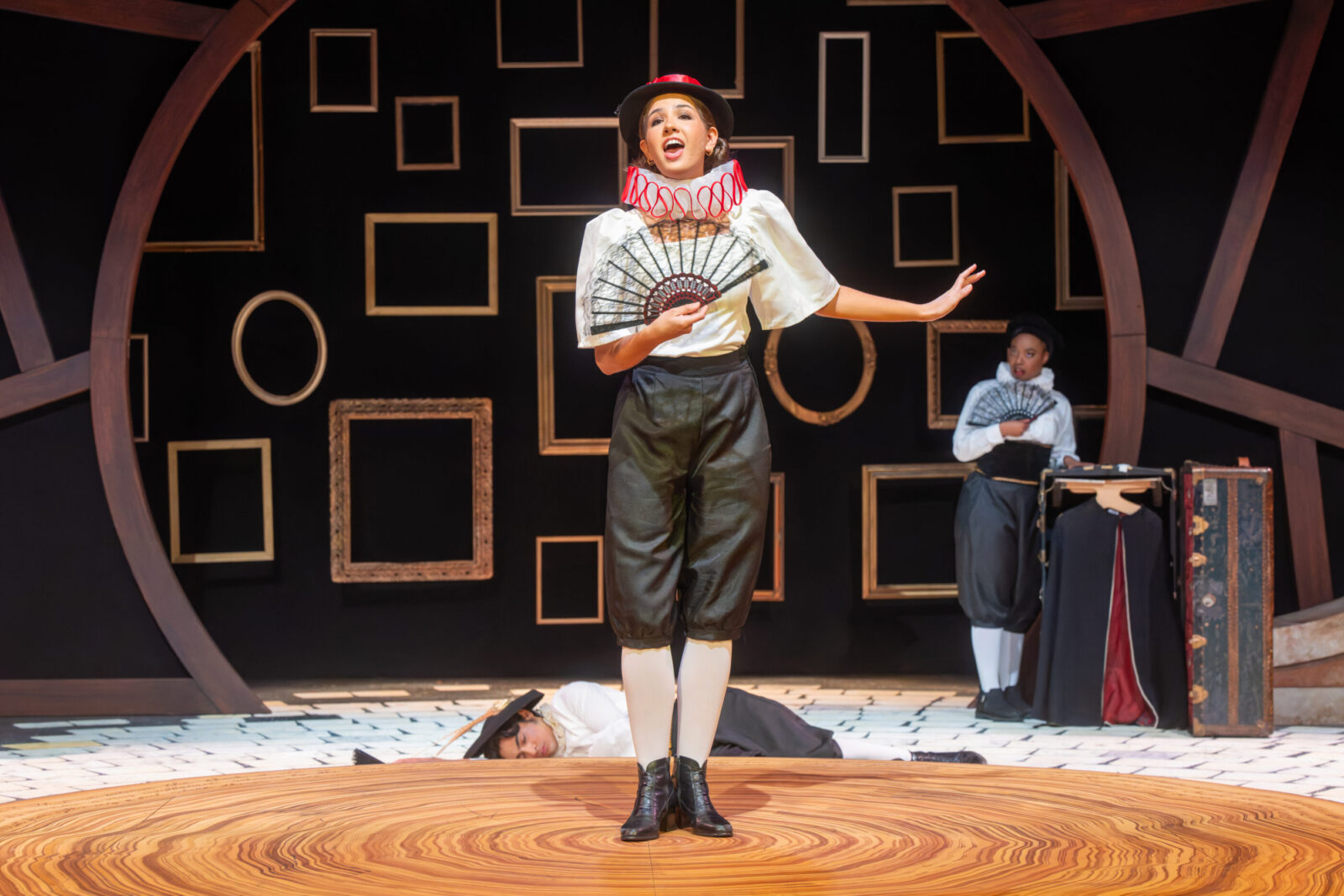 several people onstage, one on knees in front of a person with flowers