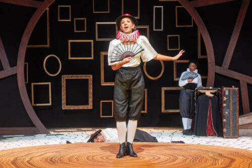 several people onstage, one on knees in front of a person with flowers