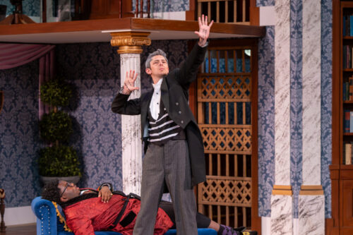 a person holds arms out high and expressivly onstage