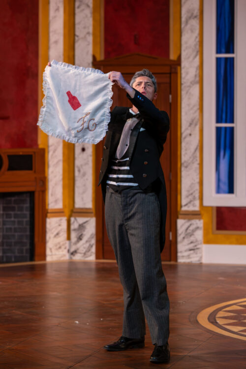 three people onstage, one is hugging another