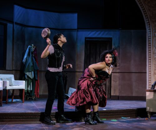 two people onstage, one is about to whack the other one with a pan