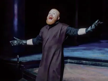 MFA actor on stage in s Shakespearean costume, gesturing outwards while shouting during a production of The Winter's Tale 