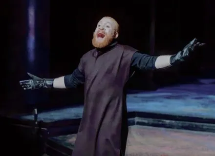 MFA actor on stage in s Shakespearean costume, gesturing outwards while shouting during a production of The Winter's Tale 