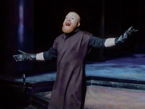 MFA actor on stage in s Shakespearean costume, gesturing outwards while shouting during a production of The Winter's Tale 