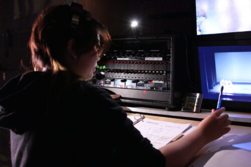 A student running a production from a board seat.