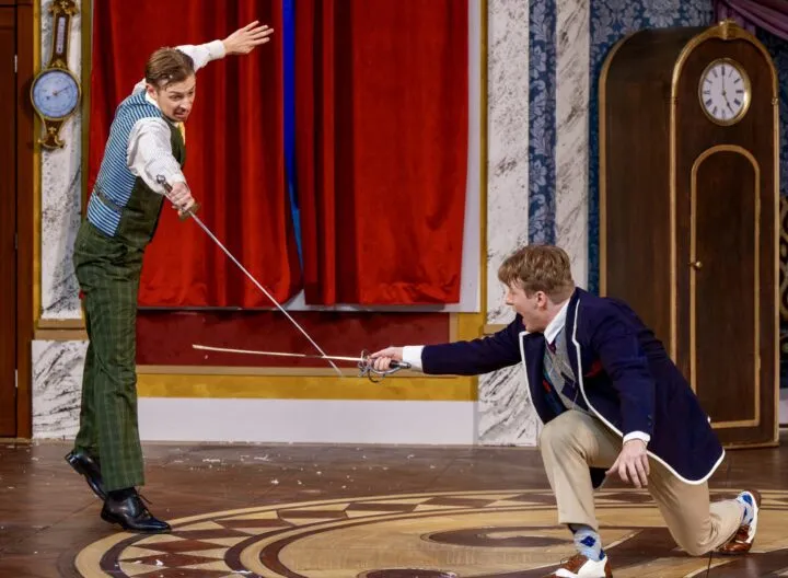 Picture from production on Playhouse stage, actors performing a staged combat scene using swords