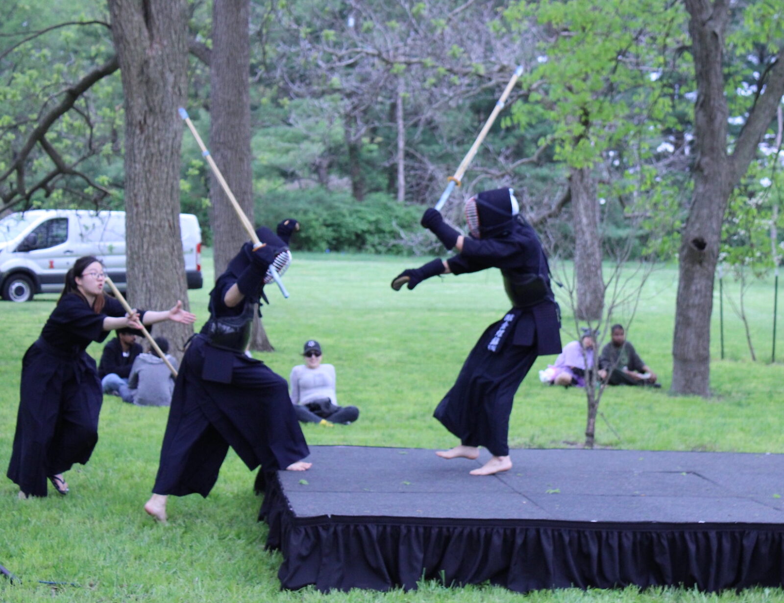 2 people fighting with wooden swords on stage