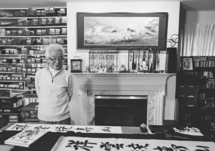 Shozo Sato in front of fireplace