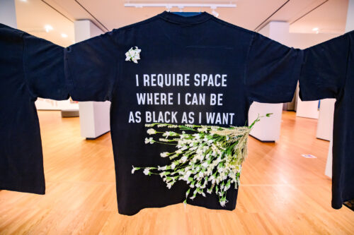 black shirt with white writing and flowers attached