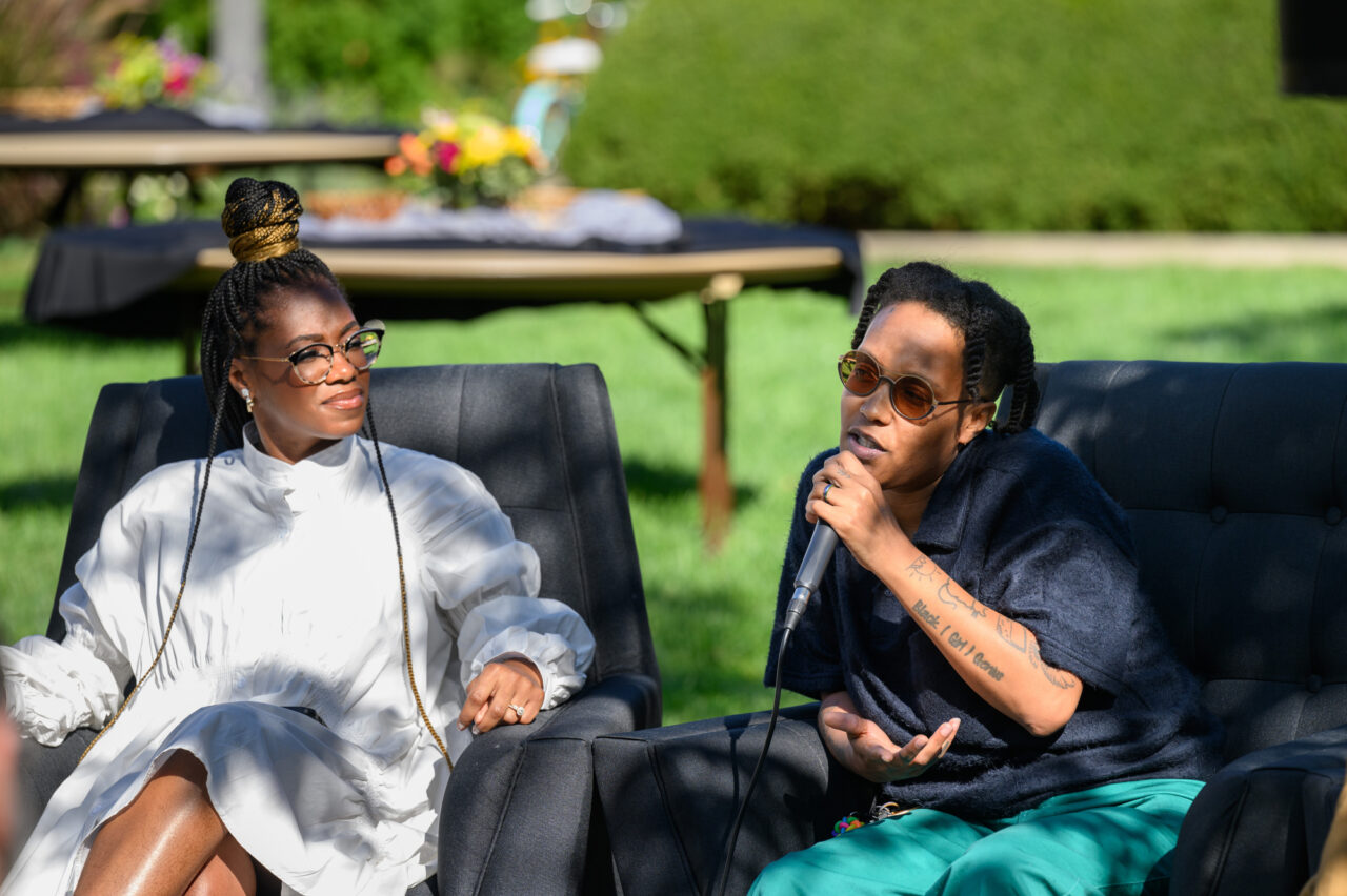 two people sit in chairs with a microphone