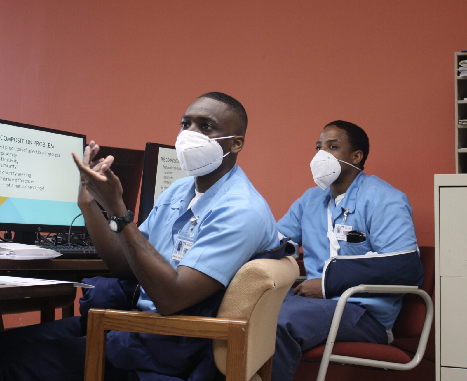 two people in blue shirts in front of computers