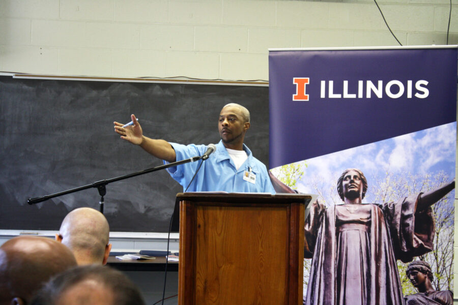 person with arm extending out and an illinois banner with alma behind