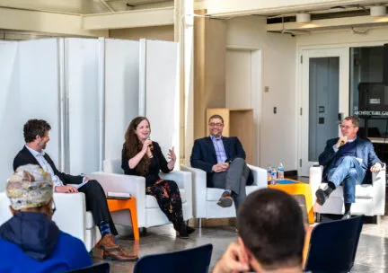 four people sitting in chairs talking