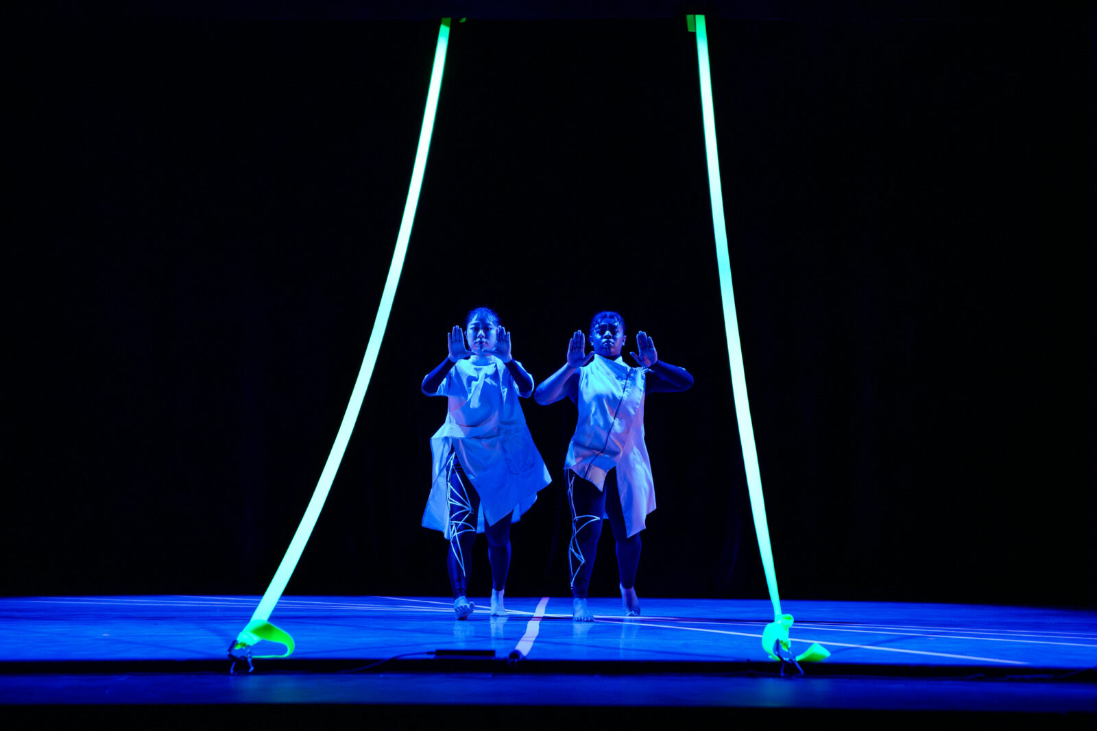 2 dancers onstage with arms up