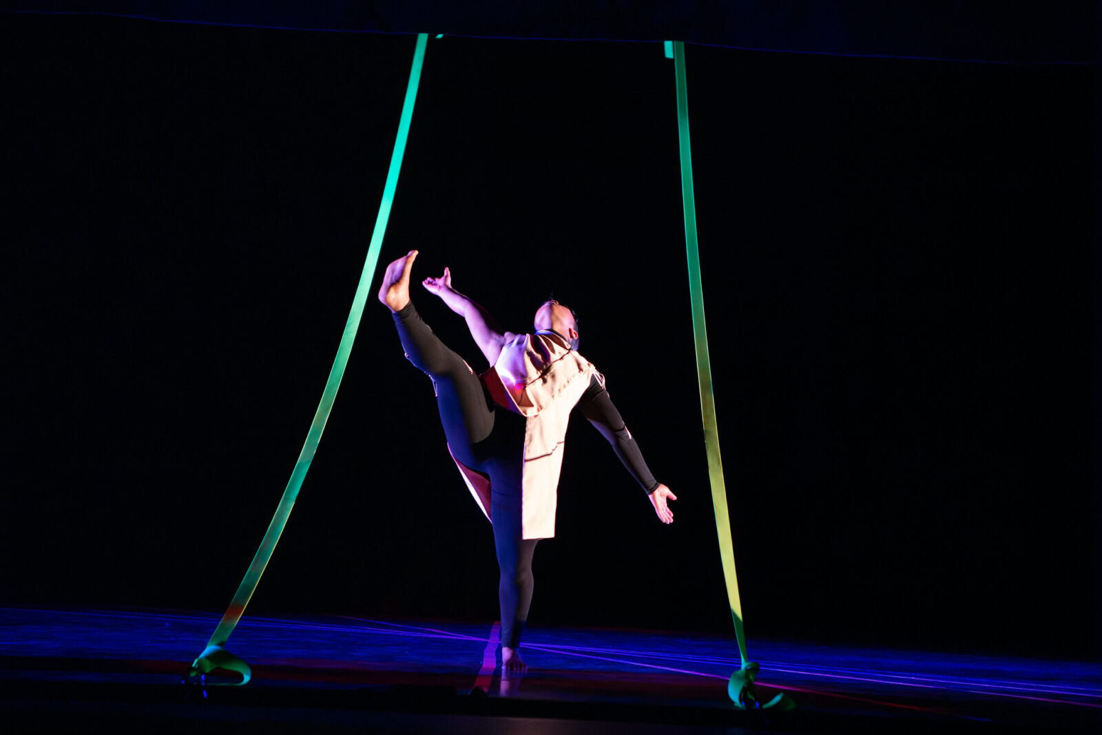 a dance onstage performing a high kick