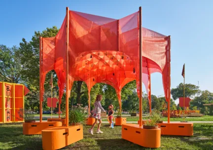 orange outdoor structure with people running through it