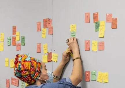 person pins post its to a wall