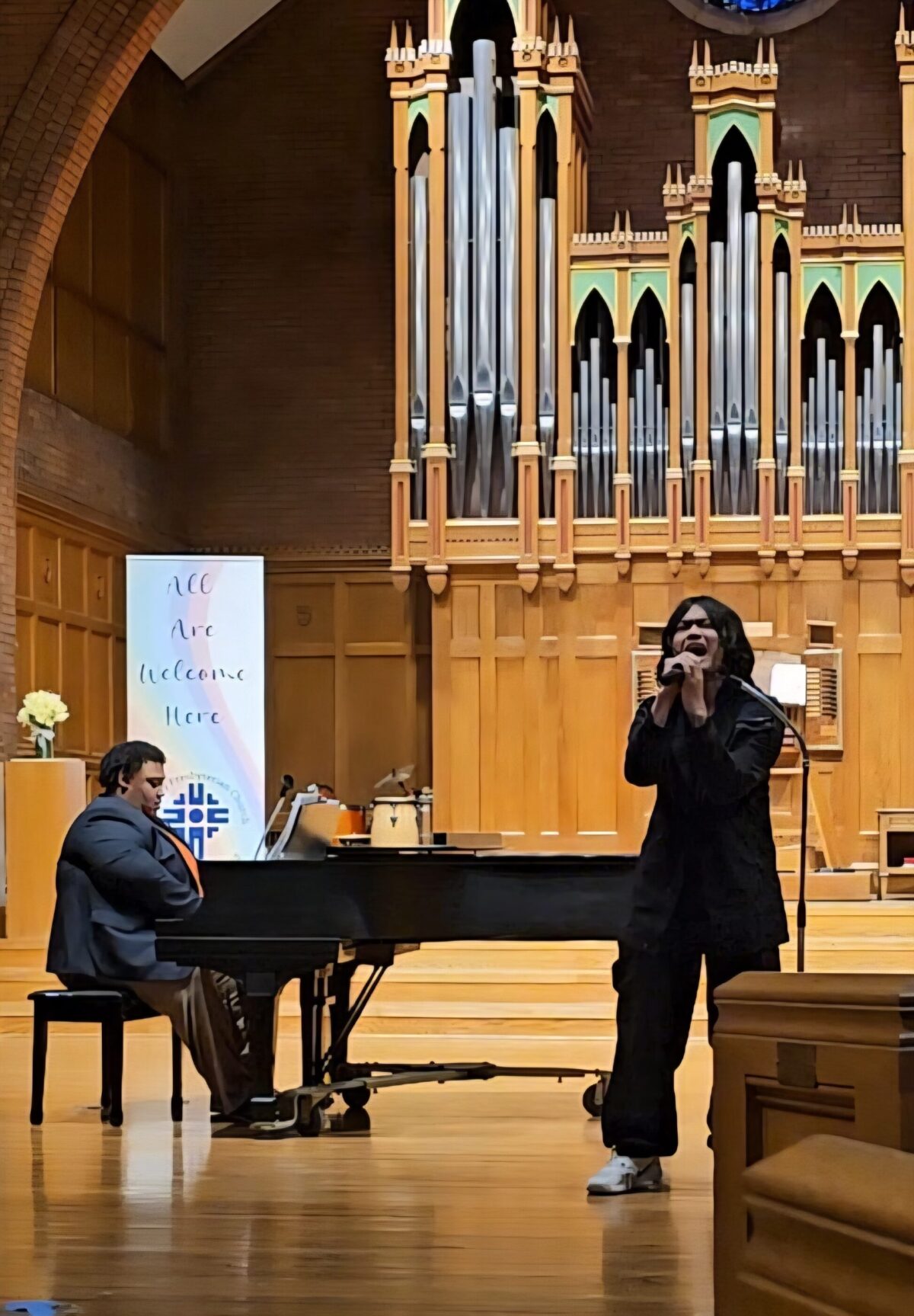 alonza plays piano while someone sings into a mic