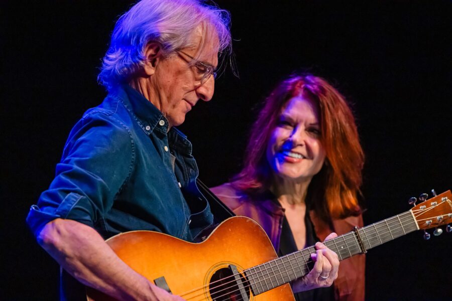 Woman looking at man playing guitar