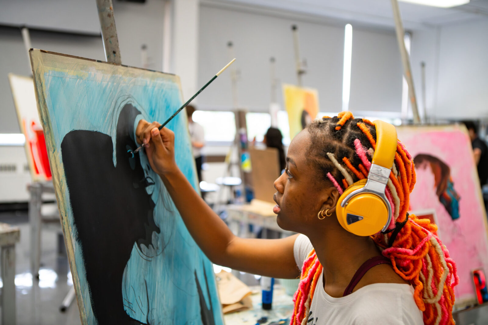 person painting with headphones on