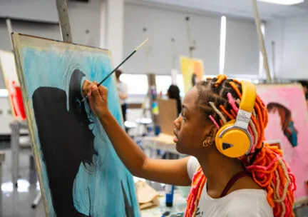 woman with headphones painting