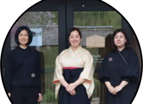 three people standing together in front of glass doors