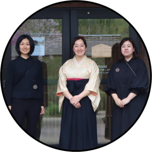 three people standing together in front of glass doors