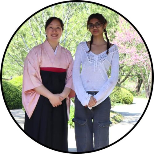 two people standing next to each other outdoors 