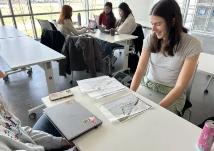 woman with papers and laptop at table